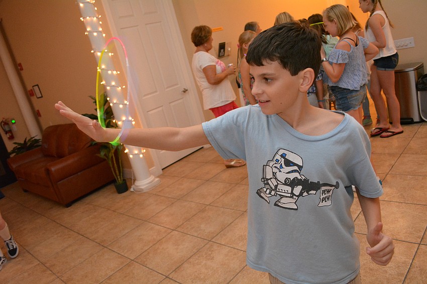 Matthew Lanni, 10, plays with a glow stick.