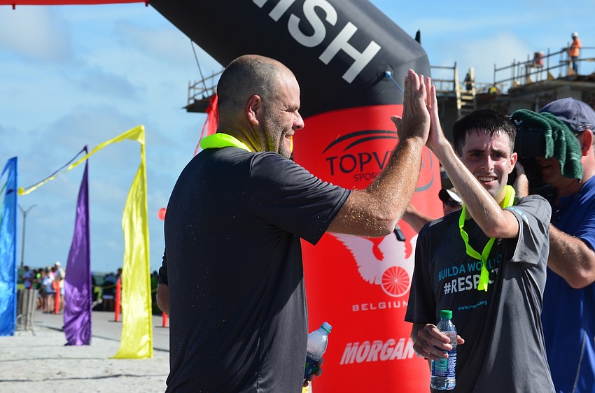 Michael Abbott from Citrus County high-five's Coach Lenard Kemp after his hard work during the race.