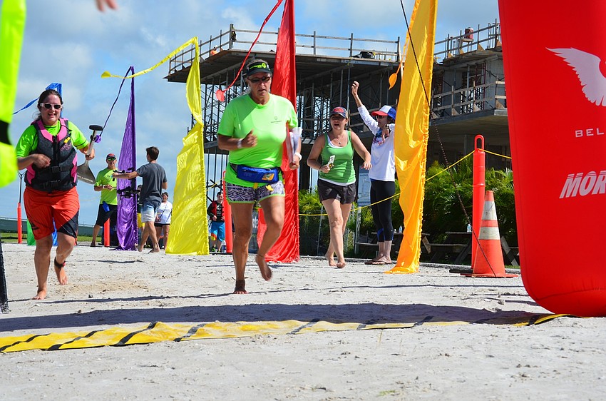 Coach Fleda Carroll accompanies Nicki Facompre as she sprints toward the the finish line.