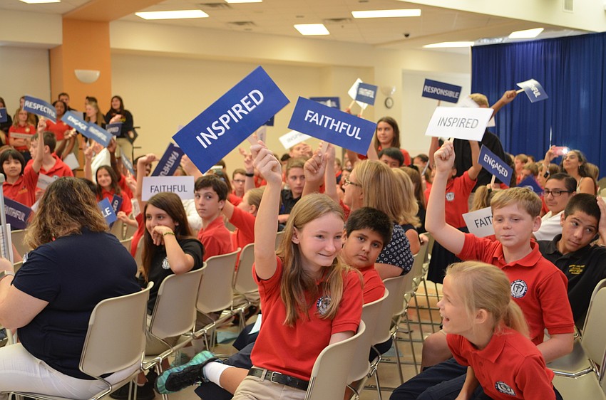 Students stand with words used to spell out the St. Mary motto of F.I.R.E.