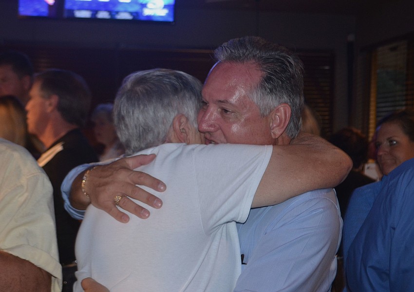 Teresa Mast's husband, Jon Mast, hugs his mother-in-law as Caroline Zucker solidified her lead in the race for the District 2 School Board race.