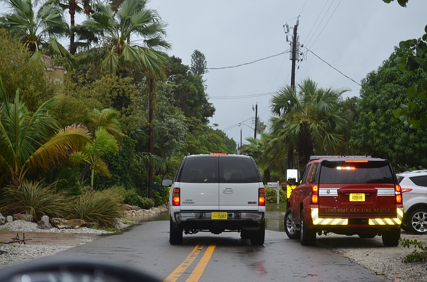 Emergency vehicles block access to a flooded Longboat Key street Thursday.