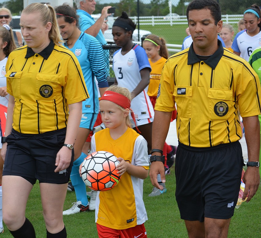 The Chargers' Karsyn Robbins, 7, had the honor of carrying the game ball on the field.