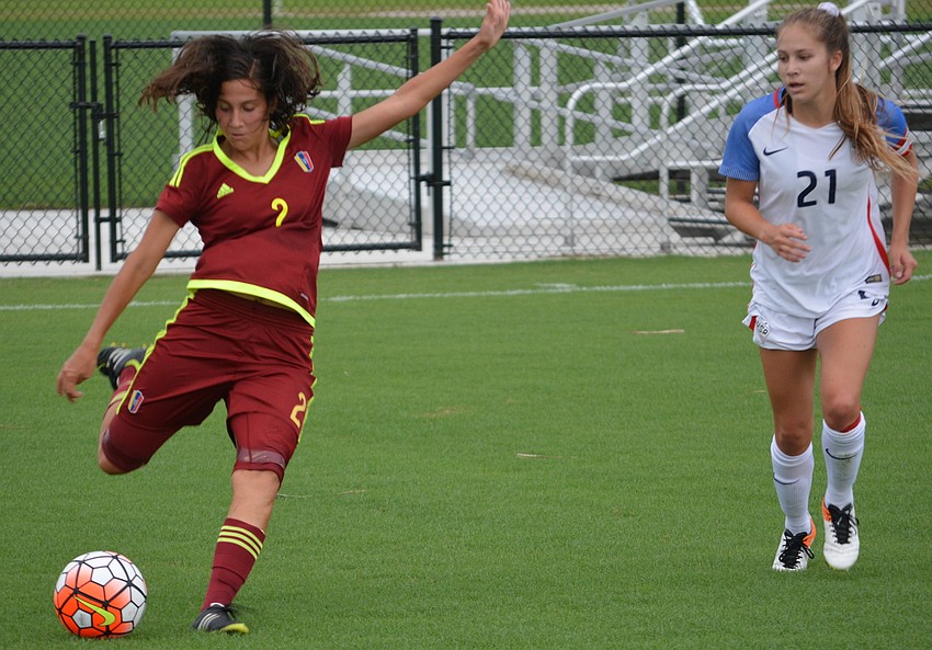 Venezuela's Veronica Herrera blasts the ball away from Ashley Sanchez of the U.S.