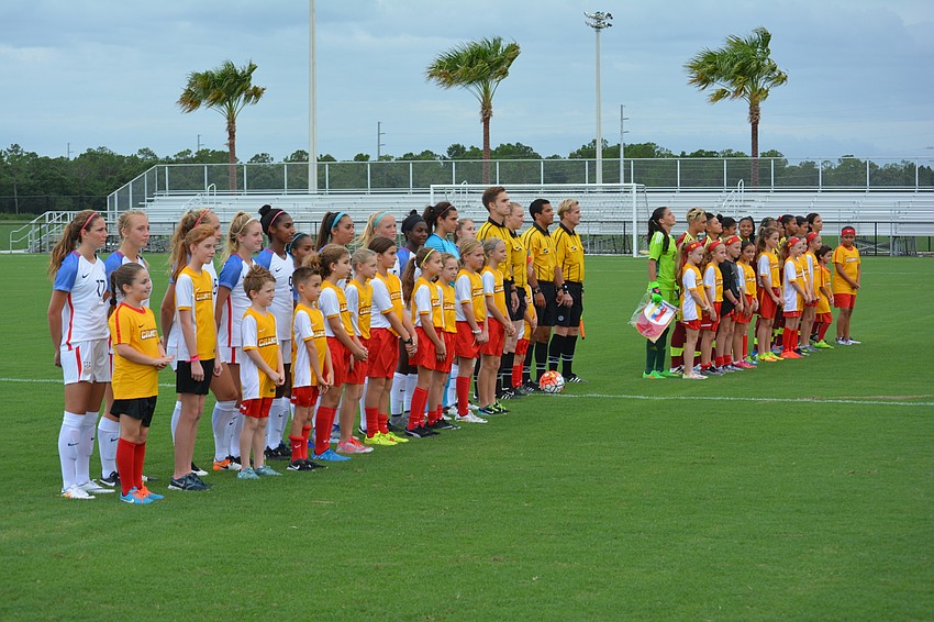 The United States and Venezuela U-17 national teams line up for ceremonies with members of the Lakewood Ranch Chargers.