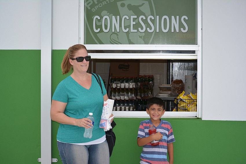 Jessica Chavez and her 6-year-old son, Madox, get a snack at Premier's new concession stand.