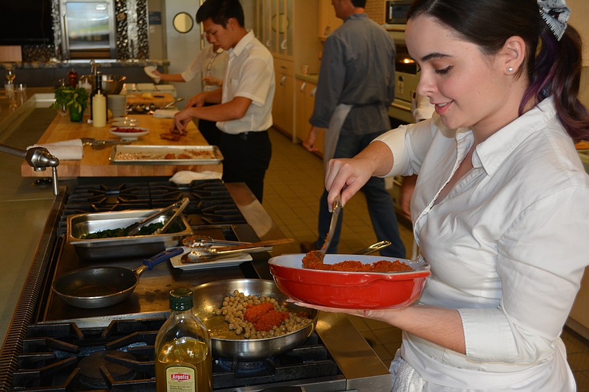 Sydney Starcher prepares more food as patrons arrive at 