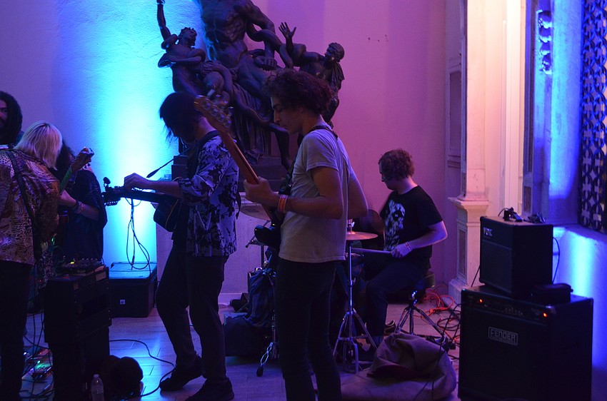 Members of Soapbox Soliloquy And The Nimbus Initiative warm up after their set was delayed and moved to a roofed area of the courtyard due to rain.