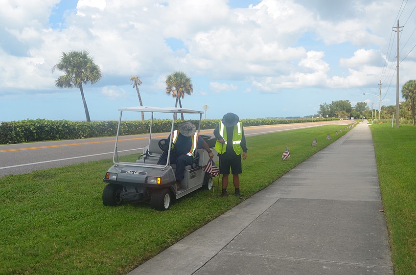 Frank Scrivani and Troy Wooten line GMD with flags on the afternoon of Sept. 9.