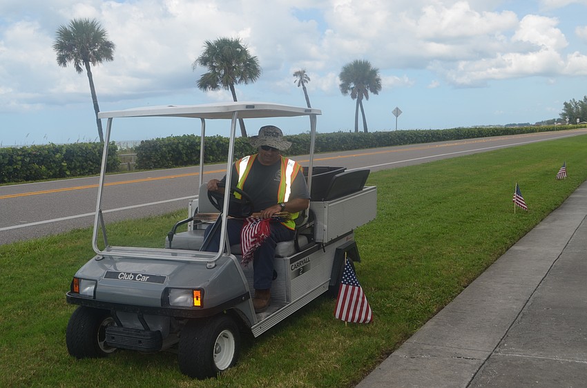 Frank Scrivani drives a golf cart while lining GMD with American flags in honor of the 15-year anniversary of 9/11.