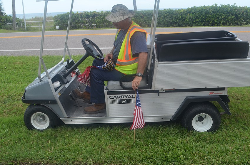 Frank Scrivani sticks an American flag along GMD.