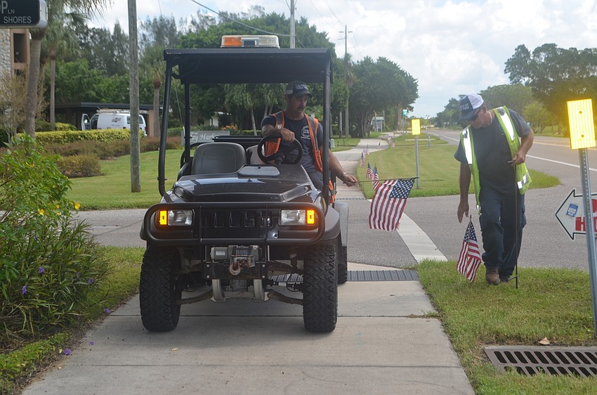Lloyd Hine and Mike Ball place American flags along GMD in honor of those who lost their life on 9/11.