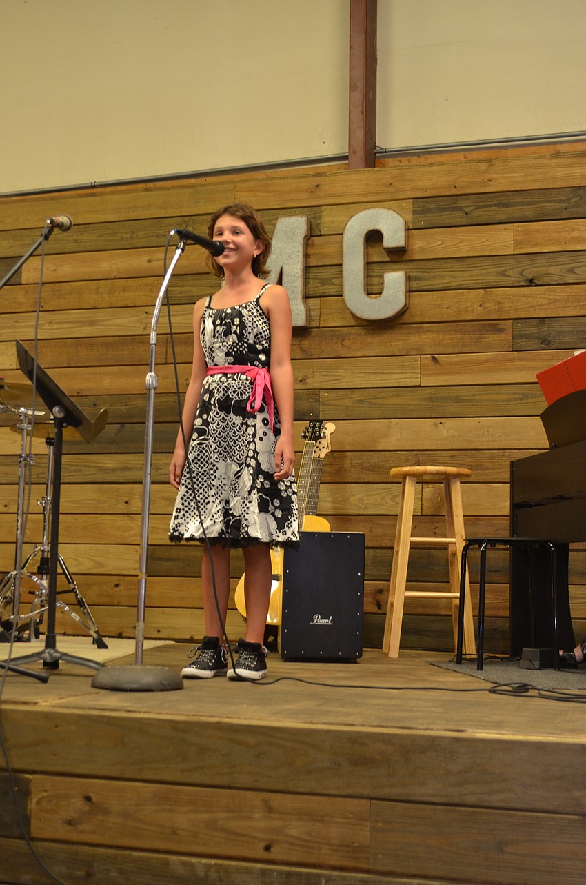Music Compound student Mia Dickey, 10, performs an original song.