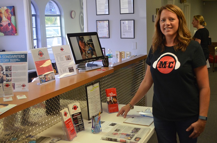 Volunteer Heather Charles welcomes attendees as they enter the Music Compound.