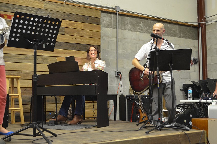Music Compound teacher Mary Sutton claps along as fellow teacher Paul Luther plays the guitar.