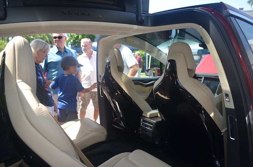 Parker Royalty, 3, checks out the interior of a 2016 Tesla Model X.