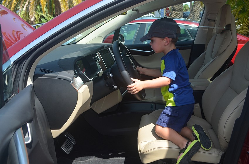 Parker Royalty, 3, takes a turn in the driver’s seat of a 2016 Tesla Model X.