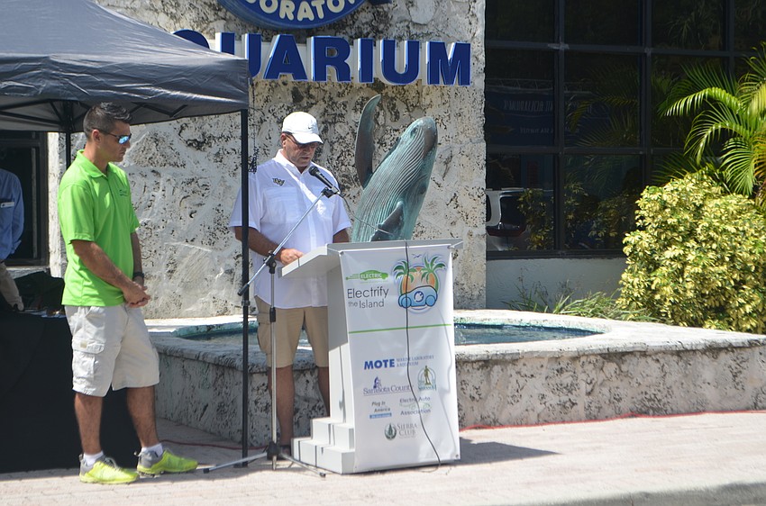 Chris Sharek stands near Tom Harmer as he proclaims the week of Sept. 10 to Sept. 18 National Drive Electric Week.