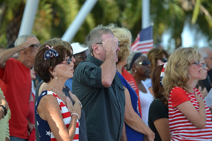 Attendees stand for the national anthem.