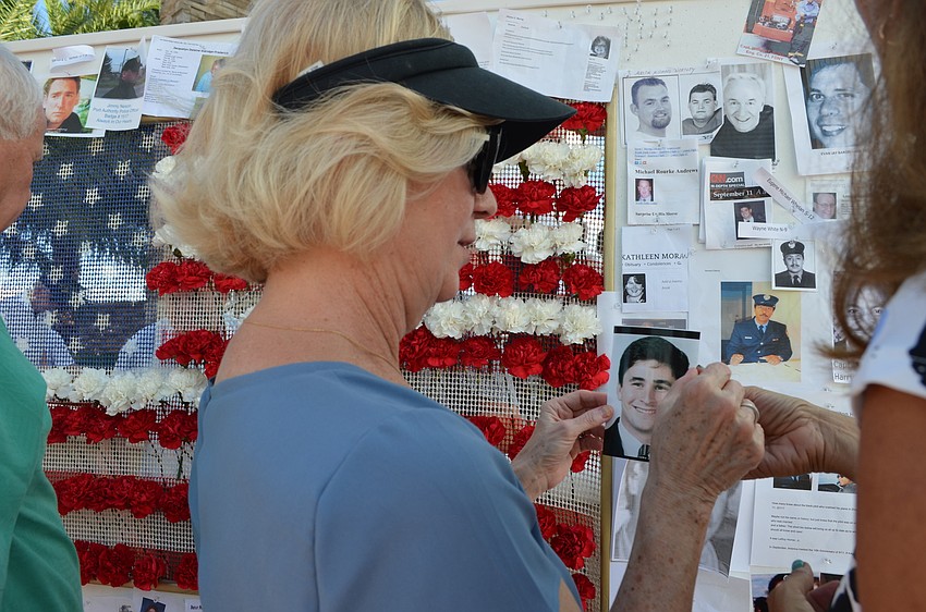 Diane Combs pins a photo of her nephew Brad Fetchet to the board.