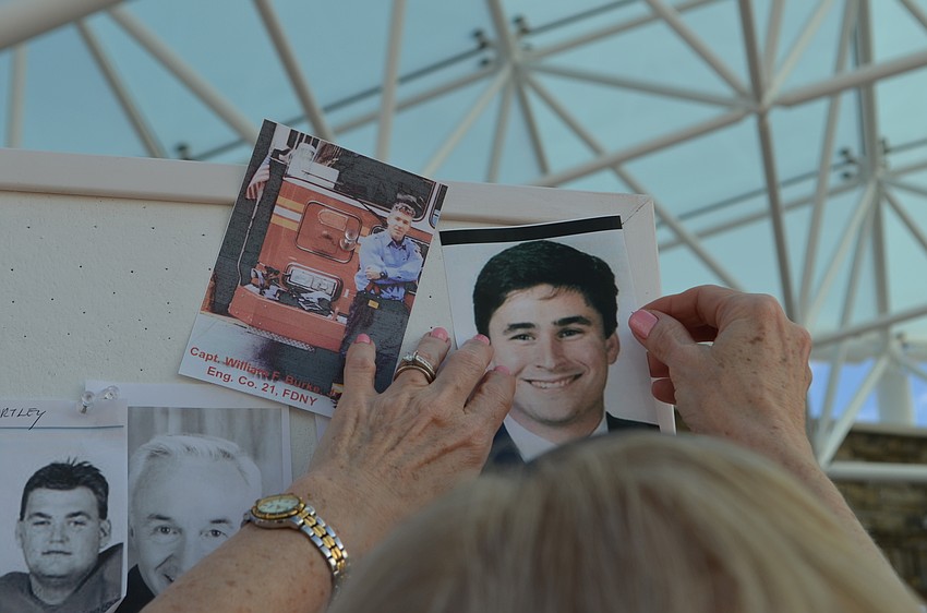 Diane Combs pins a photo of her nephew Brad Fetchet to the board.