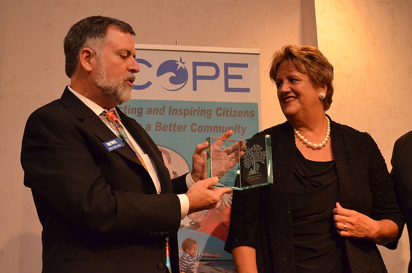 SCOPE Executive Director John McCarthy explains that the award was personalized for Barbara Shirley to include children reading.