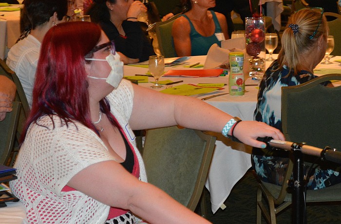 Bradenton's Katie Taaffe, who battles arthritis, listens to speakers during the Kickoff Luncheon for the Jingle Bell Run on Wednesday in Lakewood Ranch.