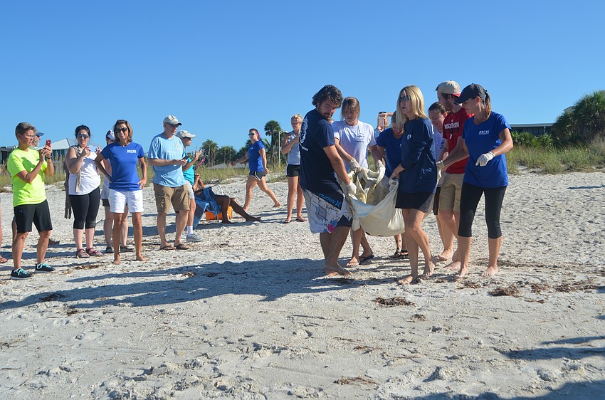 Weston Spoon, Abby Duncan, Dr. Adrienne Atkins, Jeremy Waters, Jenna Rouse and Lynne Byrd carry Tucker B. closer to the water.