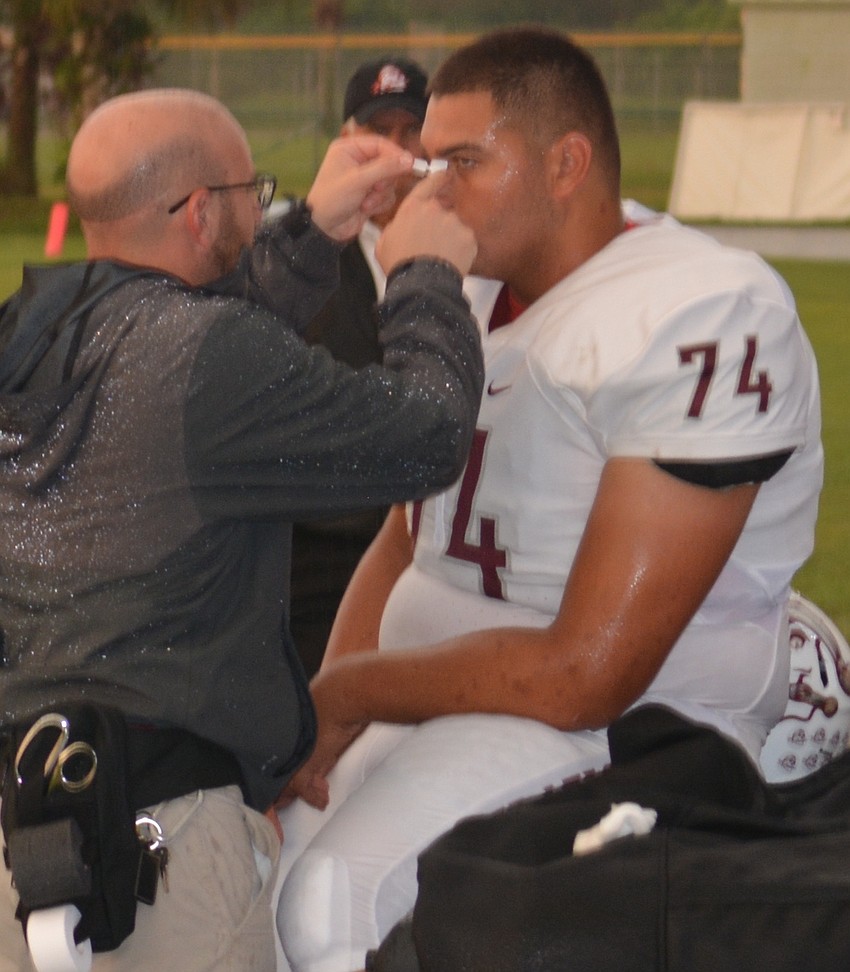 Braden River trainer Chris Gadah does a little bridge of the nose maintenance on Leo Pita before the game.