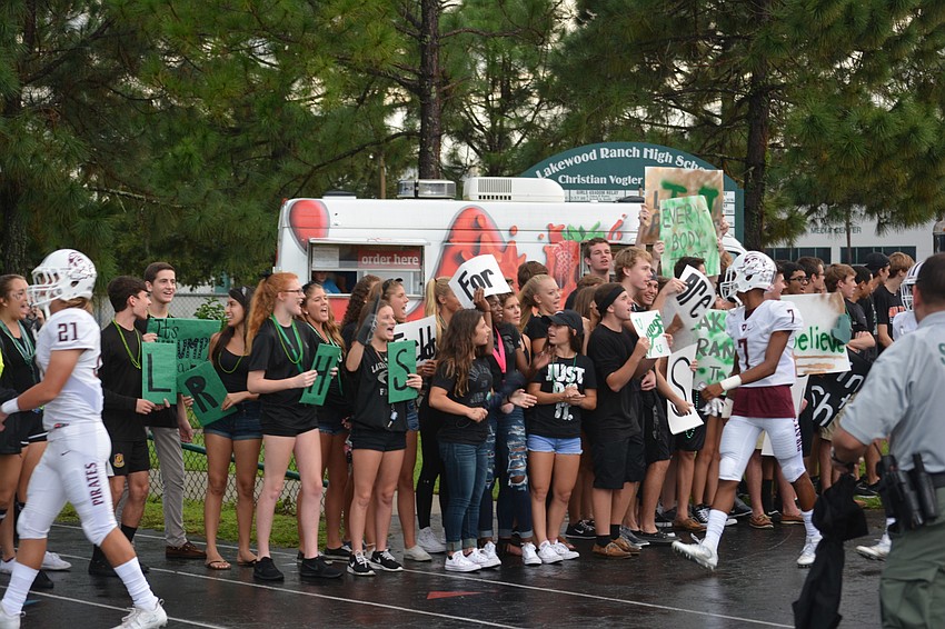 Braden River's Demetrius Lawson (7) has to walk through the gauntlet of Mustang fans as he takes the field before the game.