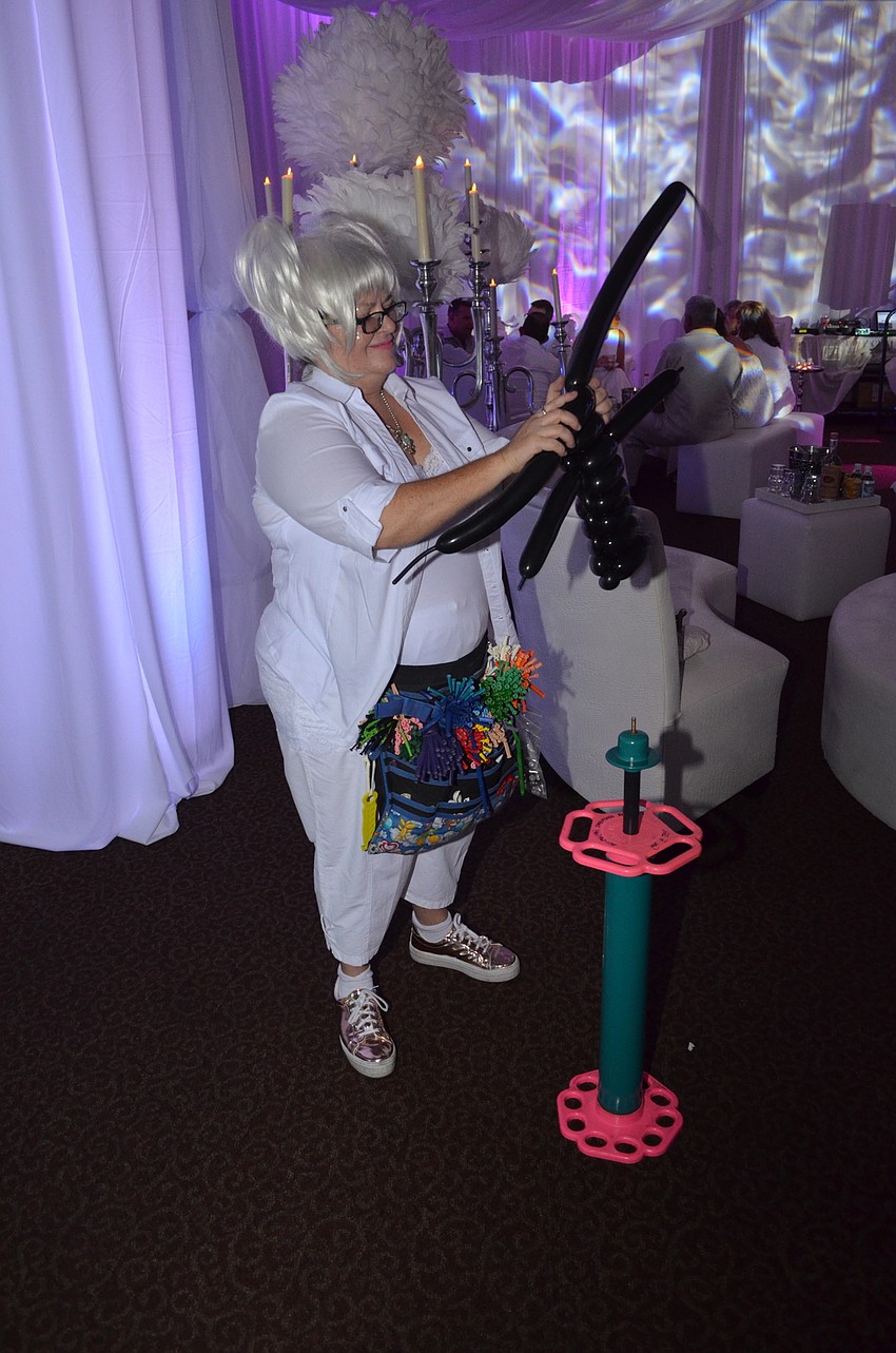 Tiffany David makes balloon hats for attendees.
