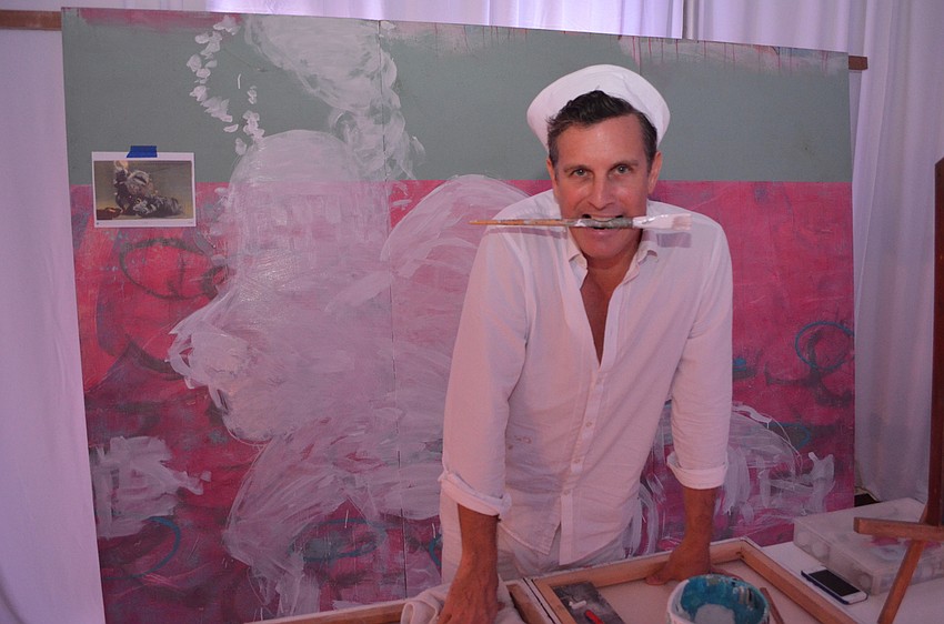 Artist Joseph Patrick Arnegger takes a break from the “live painting” he was working on during the event. The painting was made using acrylic paint and was loosely based off a vintage postcard.