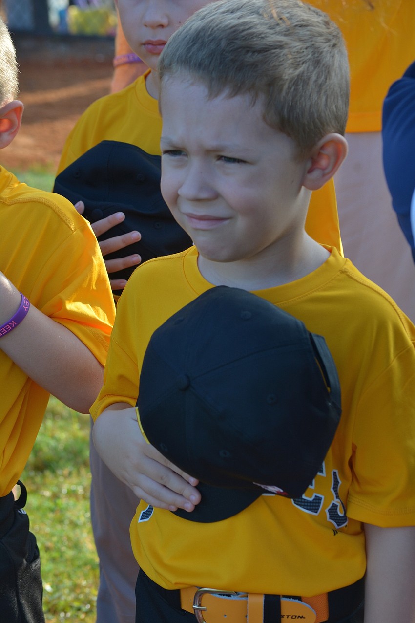 Conrad Kubilis holds his hat over his heart during the national anthem.