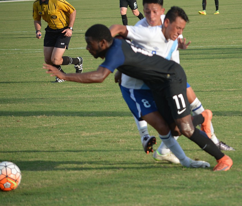 Zyen Jones of the U.S. gets tangled up with Guatemala's Adrian Paredes as he chases the ball.