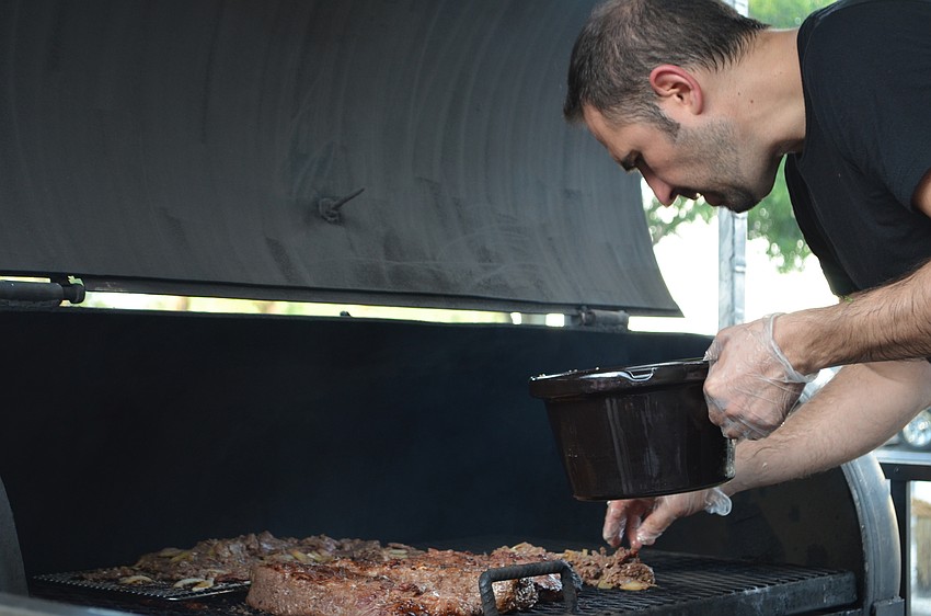Peter Miletich of World Bites Kafe checks on the smoker during the JDub's Food Truck Rally BBQ Competition Saturday, Sept. 17.