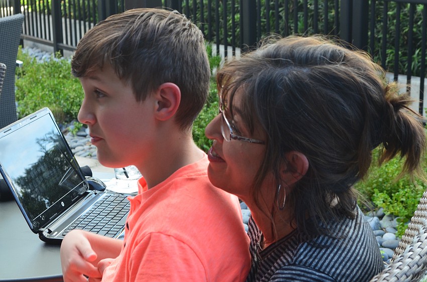 Ethan Lauk, 11, and his mom Suzy Lauk from Lakewood Ranch, sit together at Kona Grill for the Giving Challenge.