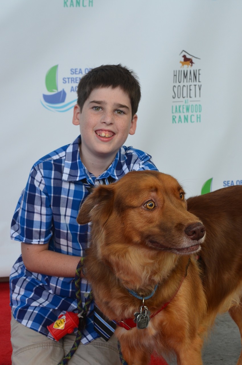 Lakewood Ranch's Eric Brady, 10, sits on the red carpet with his dog Toby.