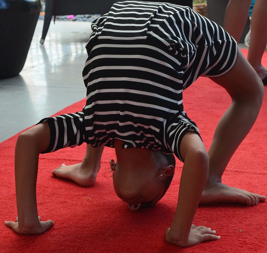 Gianna Goodwin, 10, does a back bend on the red carpet.