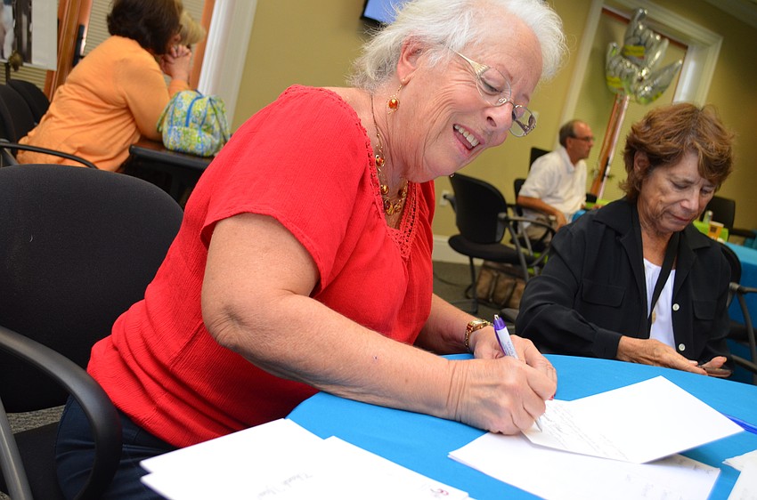 Volunteer Peg Green writes thank-you notes for donors who gave to the Sarasota Contemporary Dance studio.