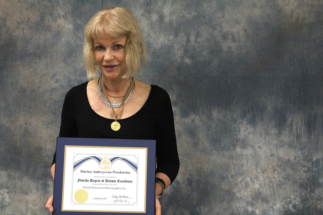 Marina Proskurina, teacher of digital design at Manatee Technical College, wears her medal and holds the unique degree she recently earned.