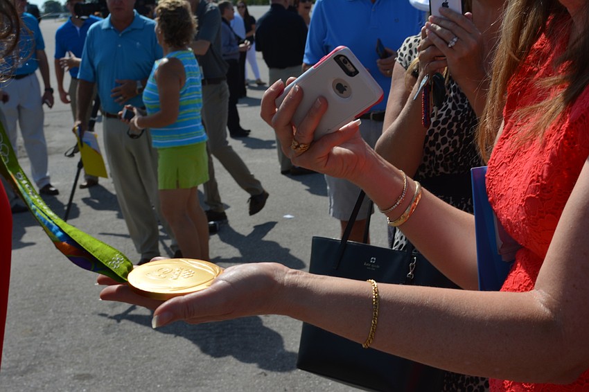 People stood in line to take photos and touch Amanda Polk's Olympic gold medal.