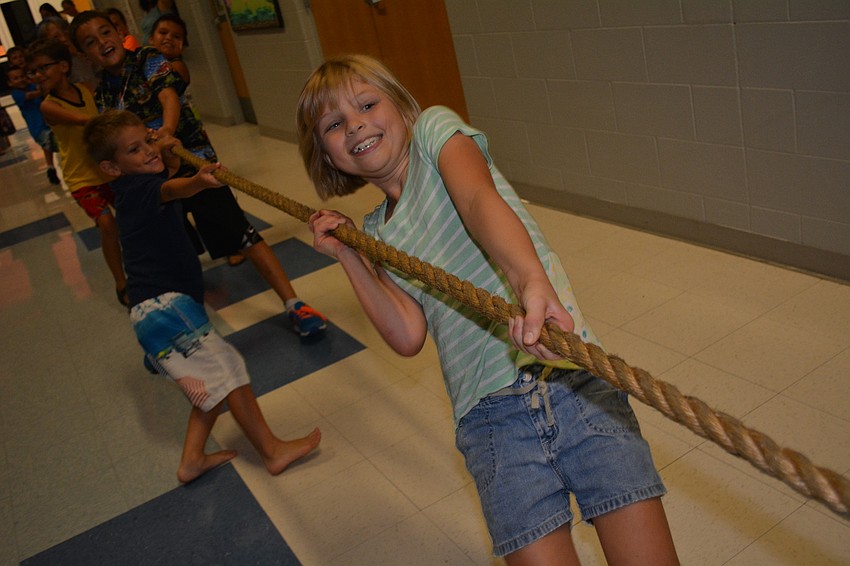Izzy Merritt,9, jumps in celebration after her team wins a battle of tug of war.