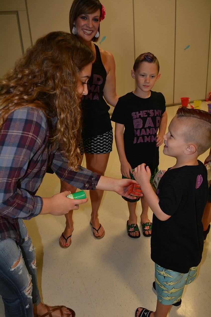 Neveah Marino, 15, colors the hair of student Blake Cleveland, a preschooler. He picked red, his favorite color.