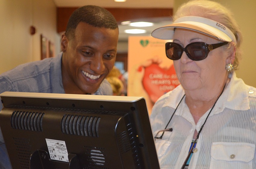 Maurice Williams, who works with Hawthorne Village, shows Sarasota's Martha Richmond how to use a balance device.