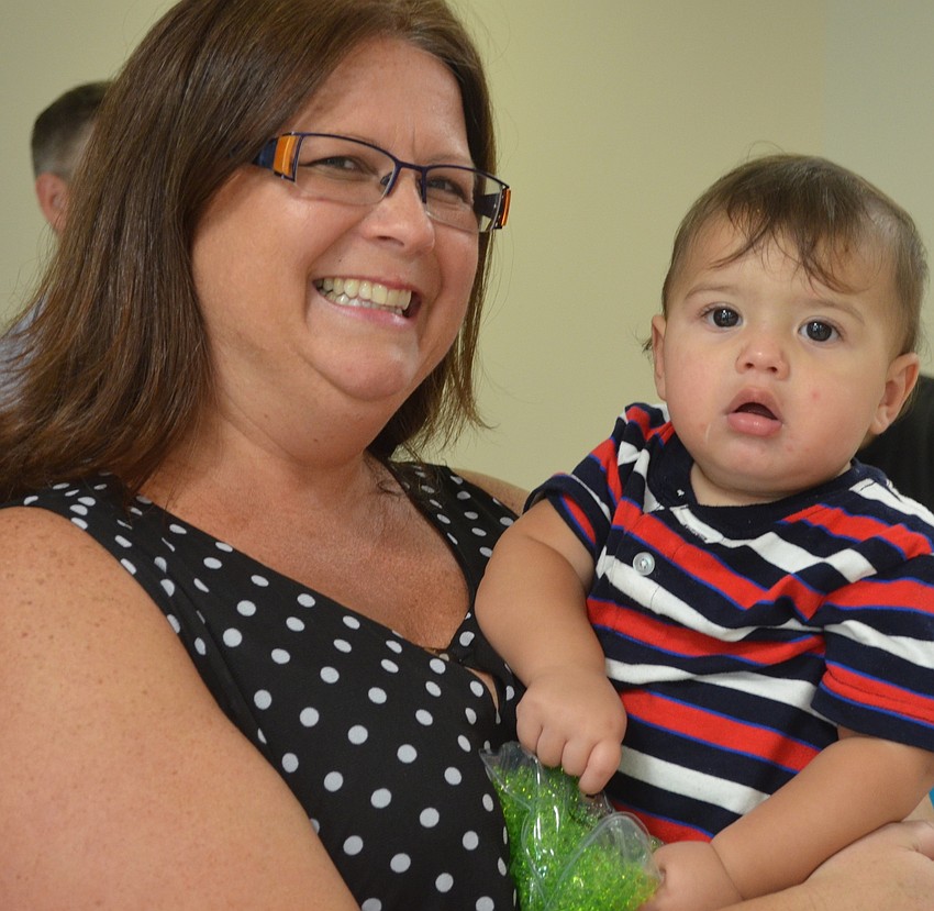 Amy Bailey, with Brookdale Senior Living Solutions, holds her son Levi Bailey, 11 months, at her booth inside the medical center.