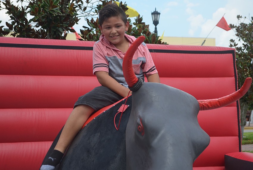 Bradenton's Eduardo Posso, 9, gets a wild ride on the mechanical bull during the Viva Latino festival.