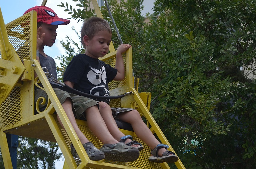 Bradenton's Logan Stevens, 4, and his brother, James Stevens, 3, enjoy a fun ride on the mini Ferris wheel.