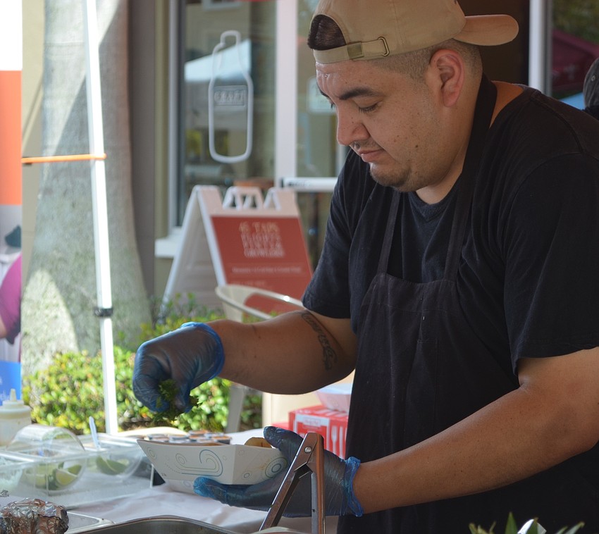 Sarasota's Jose Giron adds some fresh cilantro to the carne asada tacos he had just made.