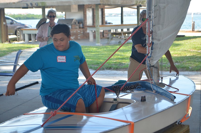 Brandon Castellana, 15, takes a turn learning how to steer a sailboat during a Manasota BUDS book club gathering on Sept. 24.