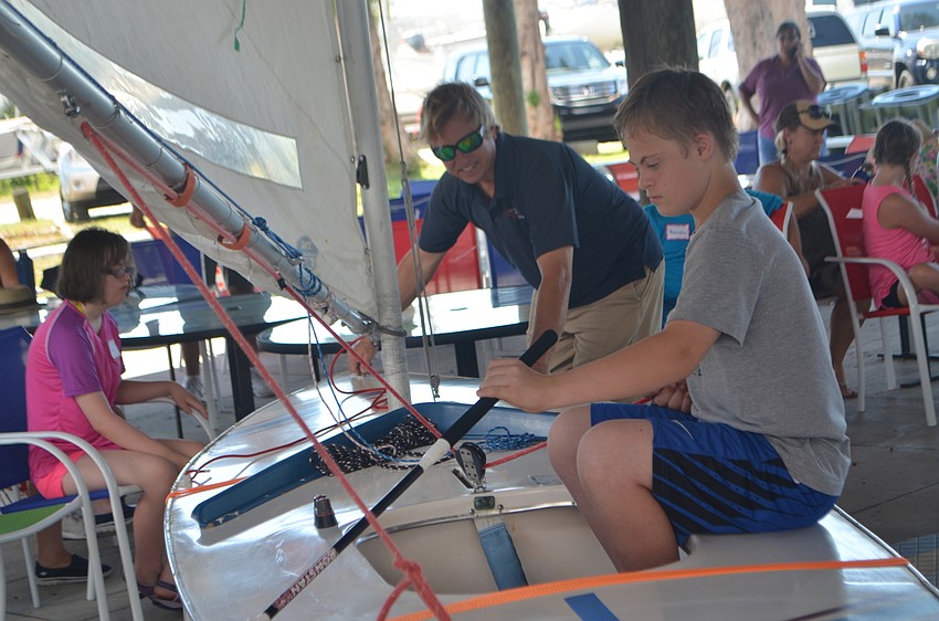 Joey Baar, 15, listens as Sarasota Sailing Squadron Director, Craig Bridges, explains how to steer a sailboat.